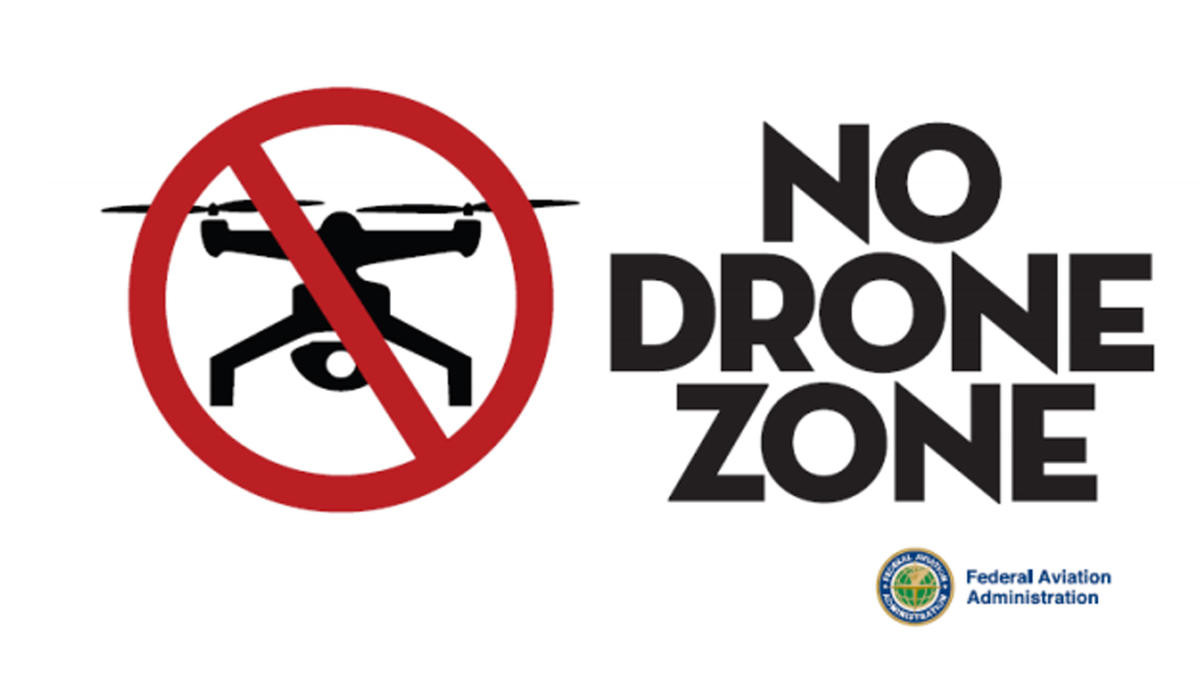 Sign with a drone icon with a red line over it and the words "No Drone Zone" with the Federal Aviation Administration logo